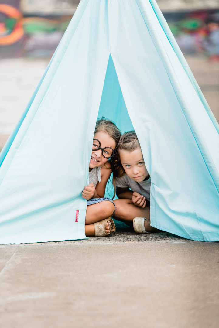 Kids peeking through turquoise blue teepee play tent