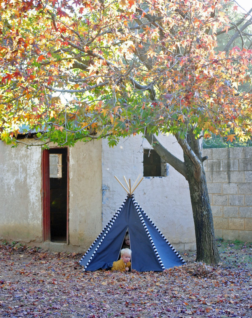 Dark grey teepee play tent under autumn tree